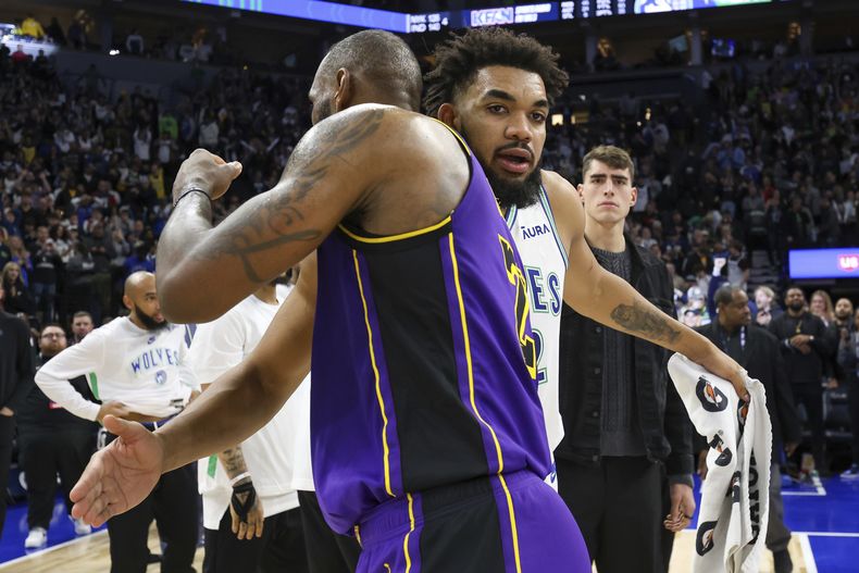 Karl-Anthony Towns, de los Timberwolves de Minnesota, y LeBron James, de los Lakers de Los Ángeles, se abrazan tras el partido del sábado 30 de diciembre de 2023 (AP Foto/Matt Krohn)