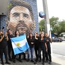Personal del restaurante Fiorito porta una bandera de Argentina frente a un mural de Lionel Messi en Miami, el miércoles 7 de junio de 2023. (AP Foto/Lynne Sladky)
