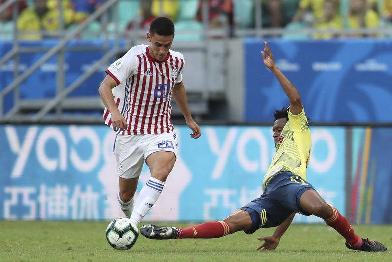 ARCHIVO - El paraguayo Matías Rojas (izquierda) y el colombiano Juan Guillermo Cuadrado disputan el balón en un partido de la Copa América, el 23 de junio de 2019, en Salvador, Brasil. (AP Foto/Natacha Pisarenko)