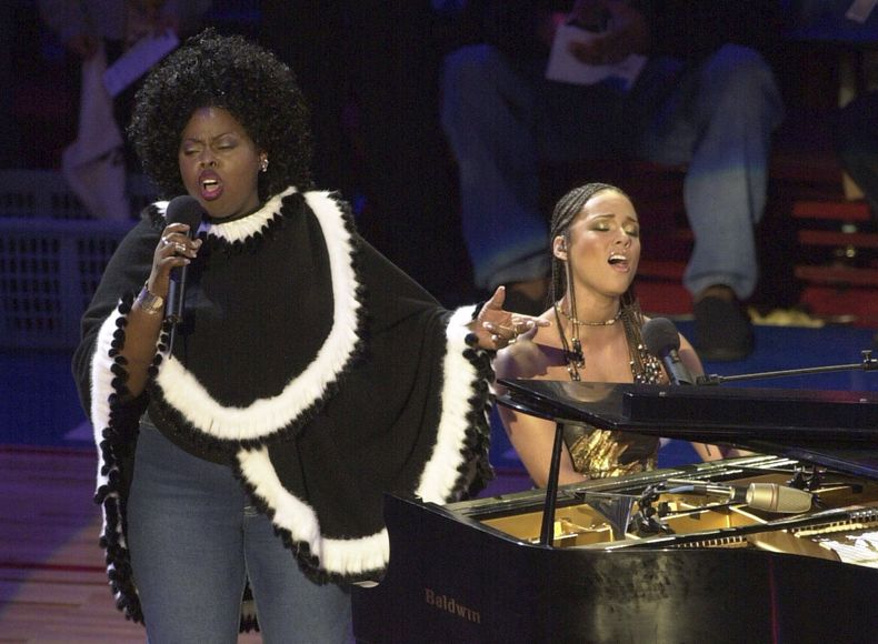 ARCHIVO - Alicia Keys, derecha, y Angie Stone interpretan America the Beautiful durante el Juego de Estrellas de la NBA, el 10 de febrero de 2002, en Filadelfia. (AP Foto/Dan Loh, archivo)