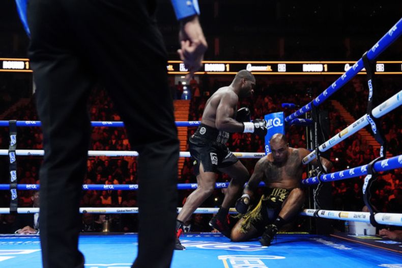 El boxeador Daniel Dubois, a la izquierda, derriba a Fabio Wardley durante su combate por el título mundial de peso pesado de la OMB, el sábado 17 de octubre de 2025, en Londres. (Nick Potts/PA vía AP)
