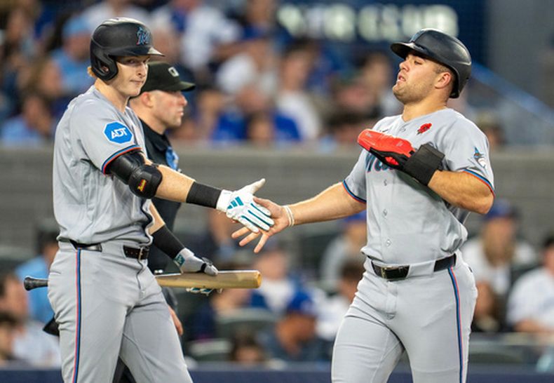 Kyle Stowers, izquierda, y Jakob Marsee, de los Marlins de Miami, celebran después de anotar durante la sexta entrada del juego de béisbol de Grandes Ligas ante los Azulejos de Toronto, el lunes 25 de mayo de 2026, en Toronto. (Frank Gunn/The Canadian Press via AP)
