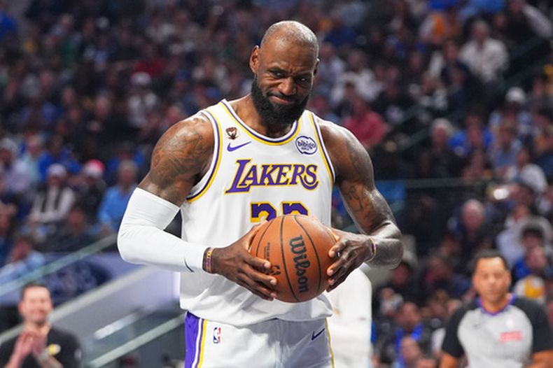 LeBron James, de los Lakers de Los Ángeles, hace una mueva mientras sujeta el balón después de un silbatazo durante la primera mitad del juego de baloncesto contra los Mavericks de Dallas, el domingo 5 de abril de 2026, en Dallas. (AP Foto/LM Otero)