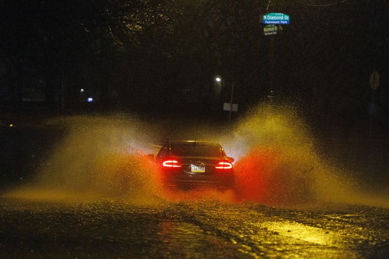 Un automóvil circula por una calle inundada en Filadelfia el 18 de diciembre de 2023. (Alejandro A. Alvarez/The Philadelphia Inquirer vía AP)