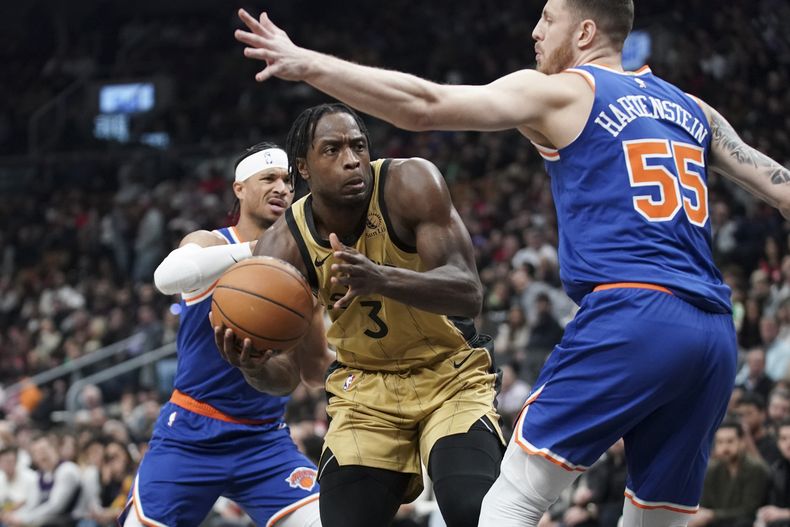 En foto del primero de diciembre del 2023, el alero de los Raptors de Toronto O.G. Anunoby intenta avanzar con el balón mientras lo defiende el pívot de los Knicks de Nueva York Isaiah Hartenstein. El sábado 30 de diciembre del 2023, Raptors envían a Anunoby a los Knicks a cambio de RJ Barrett e Immanuel Quickley. (Arlyn McAdorey/The Canadian Press via AP)