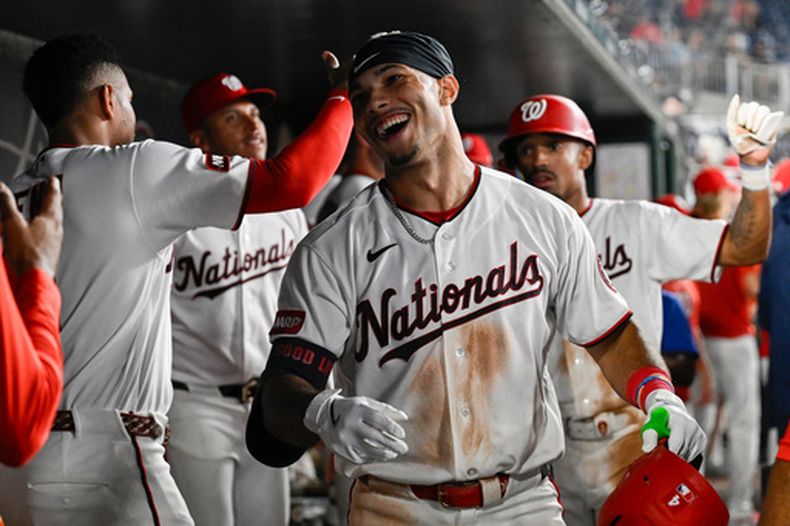 Daylen Lile, de los Nacionales de Washington, es felicitado en el dugout por sus compañeros después de conectar un cuadrangular de dos carreras durante la séptima entrada del juego de béisbol de Grandes Ligas contra los Marlins de Miami, el lunes 31 de agosto de 2026, en Washington. (AP Foto/John McDonnell)
