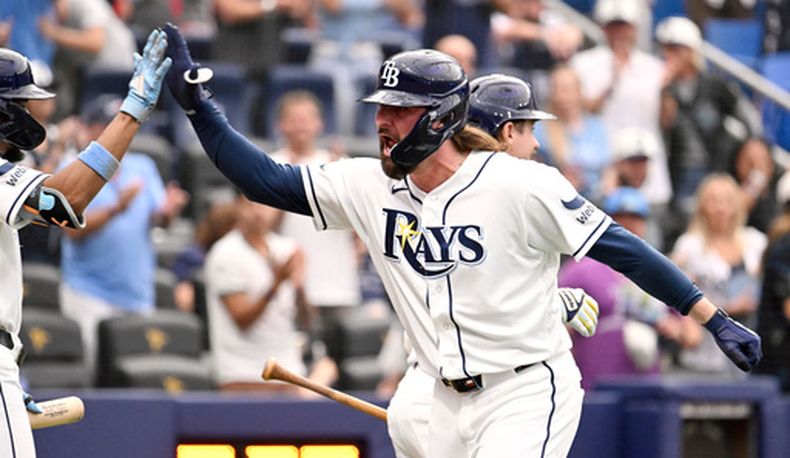 Ryan Vilade, derecha, de los Rays de Tampa Bay, celebra después de batear un jonrón de tres carreras durante la séptima entrada del juego de béisbol de Grandes Ligas contra los Marineros de Seattle el sábado 11 de julio de 2026, en San Petersburgo, Florida. (AP Foto/Jason Behnken)