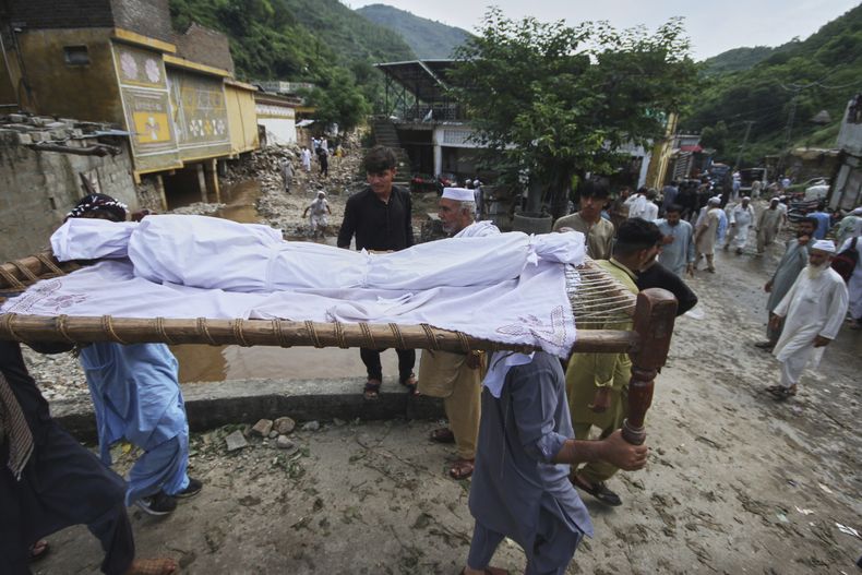 Vecinos de la zona cargan el cuerpo de un niño para un funeral después de que fuera recuperado entre los restos de una casa tras inundaciones repentinas el lunes debidas a fuertes lluvias en Dalori, un pueblo en el distrito Swabi de la provincia de Khyber Pakhtunkhwa, Pakistán, el martes 19 de agosto de 2025. (AP Foto/Muhammad Zubair)