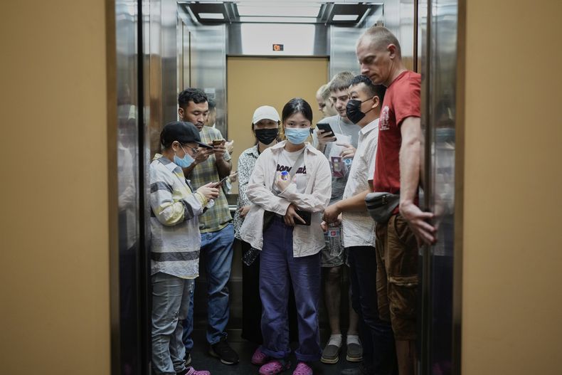 Migrantes de Afganistán, Rusia y China, que fueron deportados desde Estados Unidos, montados en un ascensor tras visitar el consulado de Australia en la Ciudad de Panamá con la esperanza de poder iniciar el proceso de solicitud de asilo en el país, el 18 de marzo de 2025. (AP Foto/Matias Delacroix)