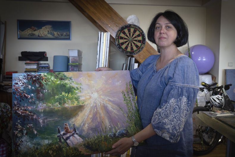Oksana Kordina muestra una obra que pintó en memoria de su marido, quien murió en una batalla con soldados rusos, en un estudio artístico en Kiev, Ucrania, el sábado 3 de junio de 2023. Para algunas mujeres ucranianas, pintar se ha convertido en una forma de terapia que les ayuda a sobrellevar la pérdida de sus compañeros muertos en la guerra. En un estudio iluminado por el sol, crean obras de arte que representan su dolor. (AP Foto/Efrem Lukatsky)
