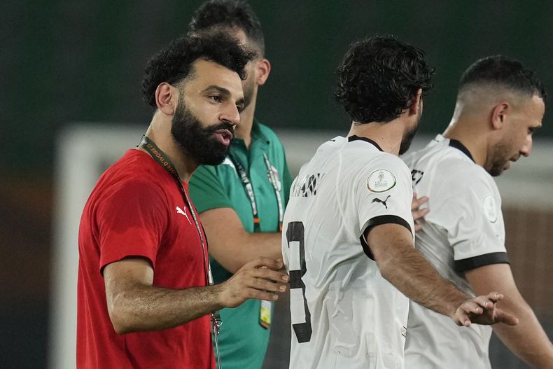 El delantero egipcio Mohamed Salah (izquierda) consuela a sus compañeros de selección después de que permitieron el gol del empate tardío durante el partido correspondiente al Grupo B de la Coa Africana de Naciones contra Cabo Verde, en el estadio Felix Houphouet Boigny, en Abiyán, Costa de Marfil, el lunes 22 de enero de 2024. (AP Foto/Themba Hadebe)