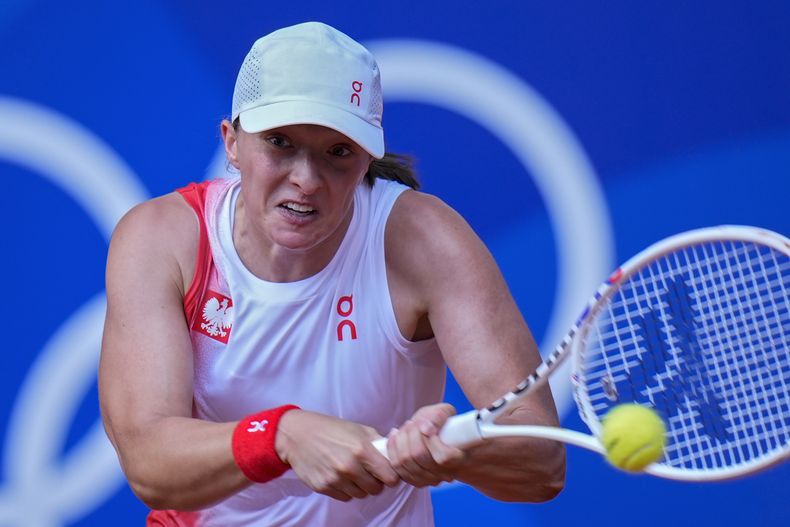 La polaca Iga Swiatek regresa el tiro de la eslovaca Anna Karolina Schmiedlova en el encuentro por la medalla de bronce en los Juegos Olímpicos el viernes 2 de agosto del 2024. (AP Foto/Andy Wong)