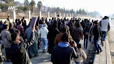 americateve | Una imagen de periodistas ciudadanos cedida por el Centro de Medios de Alepo, que ha sido autentificada por su contenido y reportajes de la AP, muestra a sirios con el Cor&aacute;n durante una manifestaci&oacute;n para detener los combates entre el EIIL y