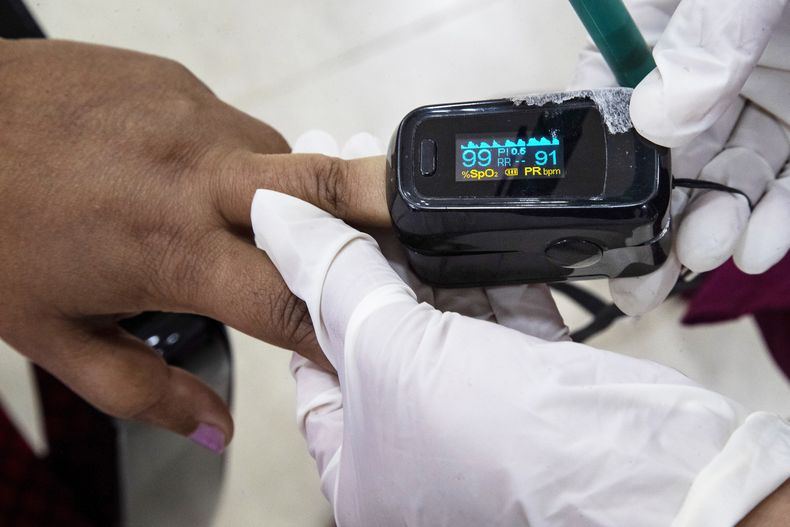 Una persona usa un oxímetro tras recibir la vacuna contra el COVID-19 en un hospital en Gauhati, India, el 21 de enero del 2021. (AP foto/Anupam Nath)