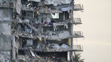 ARCHIVO - Una lona gigante en la parte inferior de la imagen cubre una sección de escombros en el edificio de condominios Champlain Towers South, en Surfside, Florida, el 4 de julio de 2021. (AP Foto/Lynne Sladky, Archivo)
