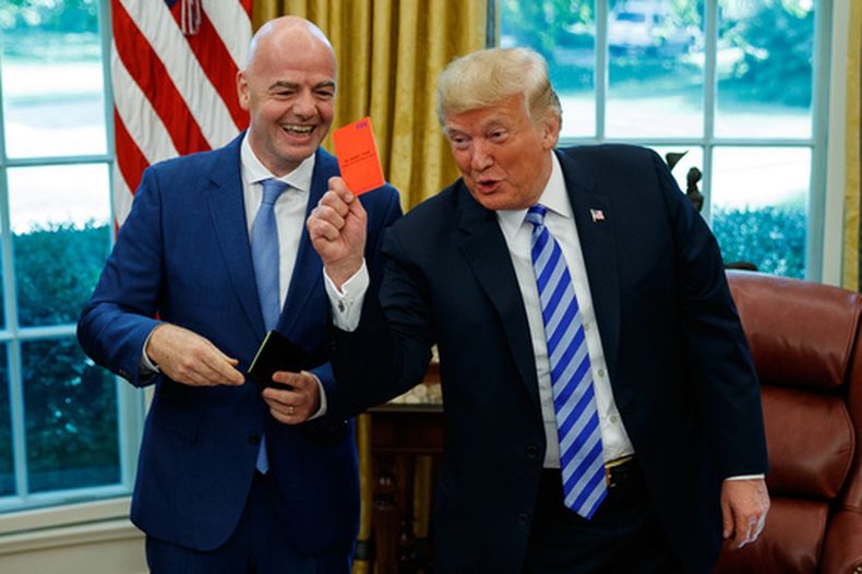 ARCHIVO - Foto del martes 28 de agosto del 2018, el presidente de los Estados Unidos Donald Trump sostiene una tarjeta roja en una reunión con el presidente de la FIFA Gianni Infantino en la Oficina Oval en la Casa Blanca. (AP Foto/Evan Vucci, Archivo)