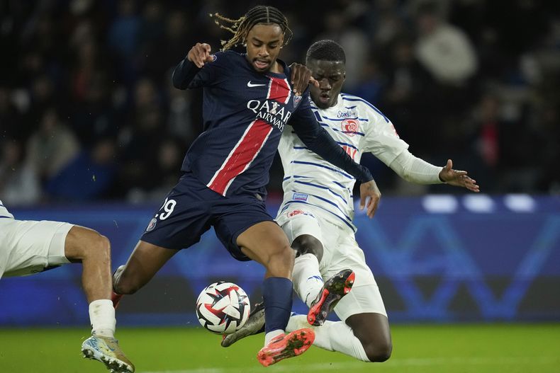 ARCHIVO - Bradley Barcola, del PSG, en el centro, es desafiado por Mamadou Sarr, a la derecha, y Diego Moreira, del Estrasburgo, durante el partido de fútbol de la Liga 1 francesa entre el Paris Saint-Germain y el Estrasburgo en el Parque de los Príncipes en París, el 19 de octubre de 2024. (AP Photo/Christophe Ena, Archivo)
