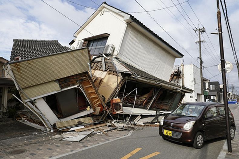 Un vehículo pasa junto a casas derrumbadas tras un terremoto en Yatsushiro, en la prefectura de Kumamoto, el miércoles 29 de julio de 2026. (Juntaro Yokoyama/Kyodo News vía AP)