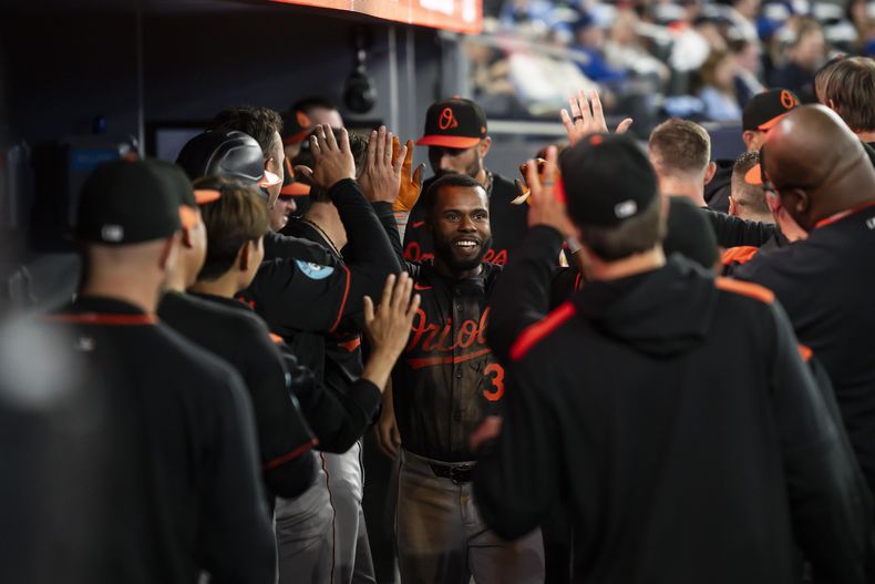 Cedric Mullins (centro) de los Orioles de Baltimore luego de batear un jonrón ante los Azulejos de Toronto, el jueves 27 de marzo de 2025, en Toronto. (Christopher Katsarov/The Canadian Press vía AP)