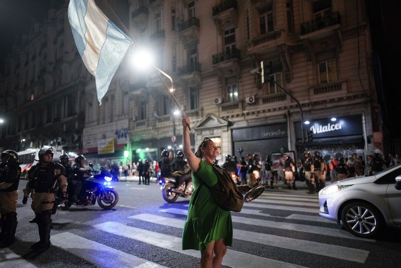Una manifestante antigobierno ondea una bandera nacional a las afueras del Congreso donde los legisladores debaten una reforma impulsada por el presidente argentino, Javier Milei, en Buenos Aires, Argentina, el jueves 1 de febrero de 2024. La propuesta incluye una amplia variedad de medidas económicas, administrativas, penales y medioambientales. (AP Foto/Natacha Pisarenko)