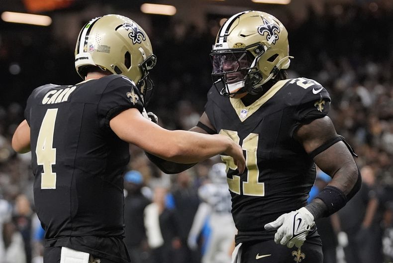 El running back de los Saints de Nueva Orleans, Jamaal Williams (21) celebra un touchdown junto al quarterback, Derek Carr (4) durante la segunda mitad del juego de la NFL ante los Panthers de Carolina, el domingo 8 de septiembre de 2024, en Nueva Orleans. (AP Foto/Gerald Herbert)