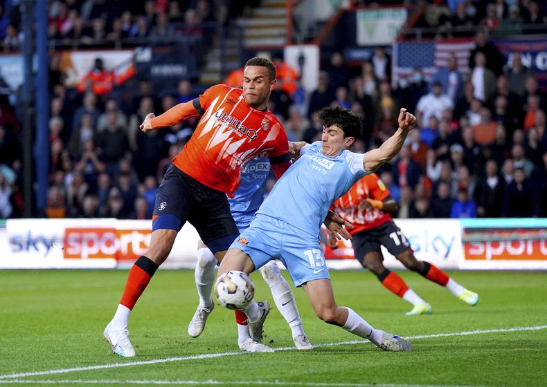 Carlton Morris, de Luton Town, y Luke ONien, de Sunderland, disputan un balón en la semifinal de ascenso, el martes 16 de mayo de 2023 (Zac Goodwin/PA via AP)