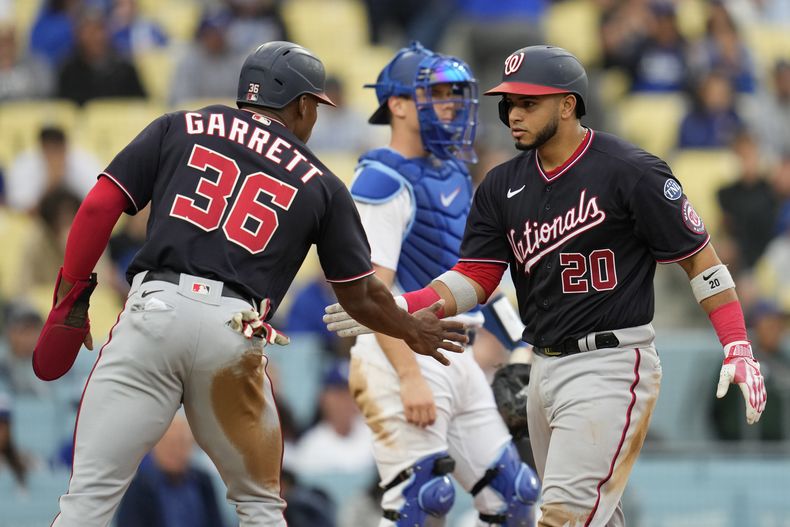 El venezolano Keibert Ruiz festeja con Stone Garrett, su compañero en los Nacionales de Washington, tras conectar un jonrón en el encuentro del miércoles 31 de mayo de 2023, ante los Dodgers de Los Ángeles (AP Foto/Ashley Landis)