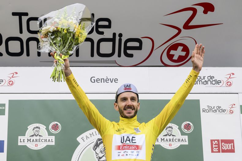 Adam Yates del equipo UAE Team Emirates celebra en el podio tras proclamarse campeón del Tour de Romandía, el domingo 30 de abril de 2023, en Ginebra. (Jean-Christophe Bott/Keystone vía AP)