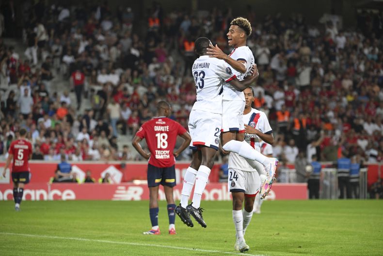 Randal Kolo Muani del Paris Saint-Germain celebra con Desire Doue tras anotar el tercer gol de su equipo en el encuentro ante Lille de la liga francesa el domingo 1 de septiembre del 2024. (AP Foto/Matthieu Mirville)