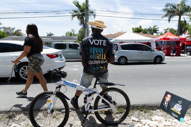 Personas llegan a un centro de votación para sufragar en la elección nacional, el martes 12 de mayo de 2026, en Nassau, Bahamas. (AP Foto/Tim Aylen)