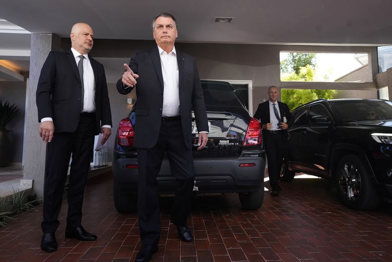 El expresidente Jair Bolsonaro hace declaraciones a la prensa afuera de su casa después de que agentes de la policía federal cumplimentaran una orden de registro y decomiso en Brasilia, Brasil, el miércoles 3 de mayo de 2023. (AP Foto/Eraldo Peres)