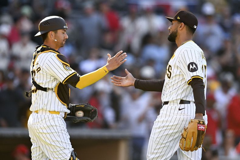 Kyle Higashioka, receptor de los Padres de San Diego, felicita al venezolano Robert Suárez, al concluir el duelo del miércoles 3 de abril de 2024, ante los Cardenales de San Luis (AP Foto/Denis Poroy)