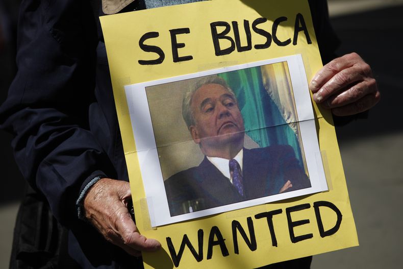 ARCHIVO - Un activista sostiene una fotografía del expresidente de Bolivia, Gonzalo Sánchez de Lozada, durante una protesta frente a la embajada de Estados Unidos en La Paz, Bolivia, el 3 de septiembre de 2010. (AP Foto/Juan Karita, Archivo)