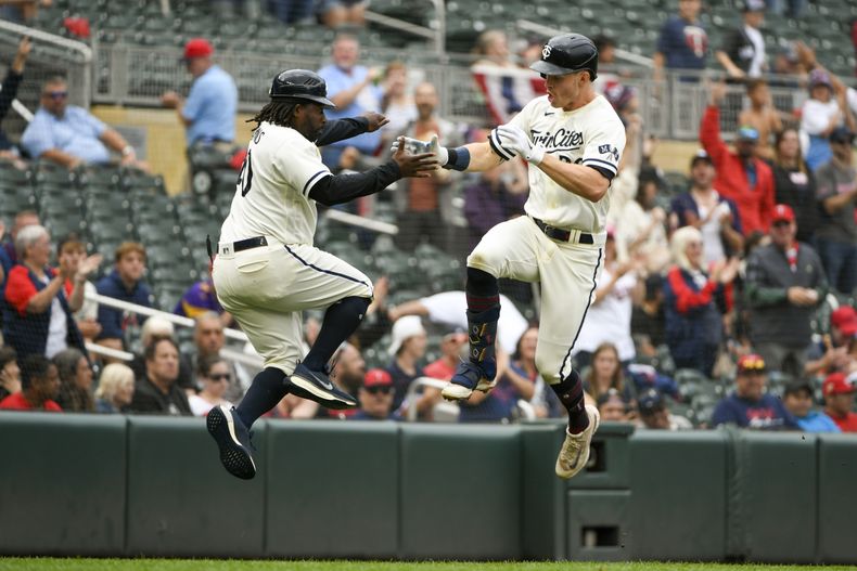 Max Kepler, derecha, de los Mellizos de Minnesota, celebra con el coach de tercera base Tommy Watkins después de batear jonrón de dos carreras en contra de los Angelinos de Los Ángeles, durante la séptima entrada del juego de béisbol el domingo 24 de septiembre de 2023, en Minneapolis. (AP Foto/Craig Lassig)
