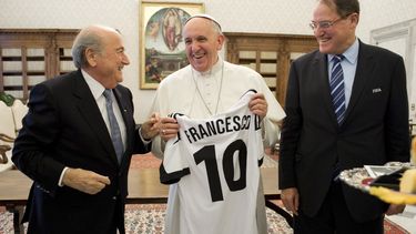 americateve | El papa Francisco, centro, sonr&iacute;e al recibir una camiseta con su nombre en una reuni&oacute;n con el presidente de la FIFA, Joseph Blatter, izquierda, en el Vaticano el viernes, 22 de noviembre de 2013. Imagen suministrada por el diario del Vatican