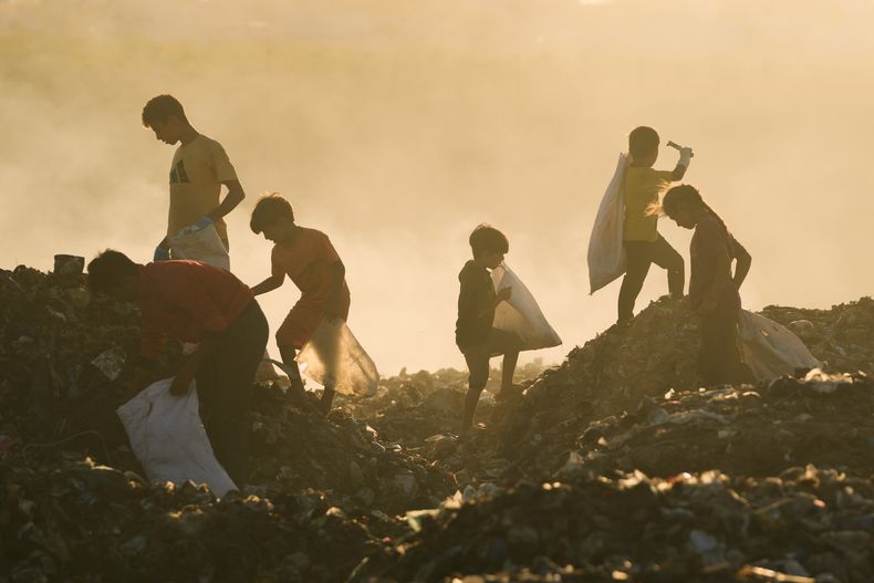 Niños palestinos desplazados buscan madera y plástico en un vertedero próximo al asentamiento improvisado de tiendas de campaña donde se refugian, en Jan Yunis, en el sur de la Franja de Gaza, el 30 de septiembre de 2025. (AP Foto/Jehad Alshrafi)