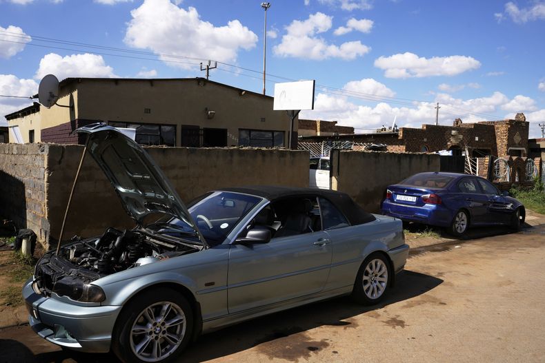 Automóviles en proceso de reparación se encuentran estacionados afuera del taller de Themba Maseko, un mecánico automotriz de 39 años de edad, el miércoles 30 de abril de 2025, en Brakpan, al este de Johannesburgo, Sudáfrica. (AP Foto/Themba Hadebe)