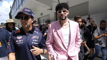 ARCHIVO - El piloto de Red Bull Sergio Pérez, de México, izquierda, camina con el reggaetonero puertorriqueño Bad Bunny antes del Gran Premio de Fórmula Uno de Miami en el Autódromo Internacional de Miami en Florida el 8 de mayo de 2022. A medida que el deporte crece en popularidad, las carreras también se están convirtiendo en una oportunidad para mini festivales de música. (Foto AP/Lynne Sladky, archivo)