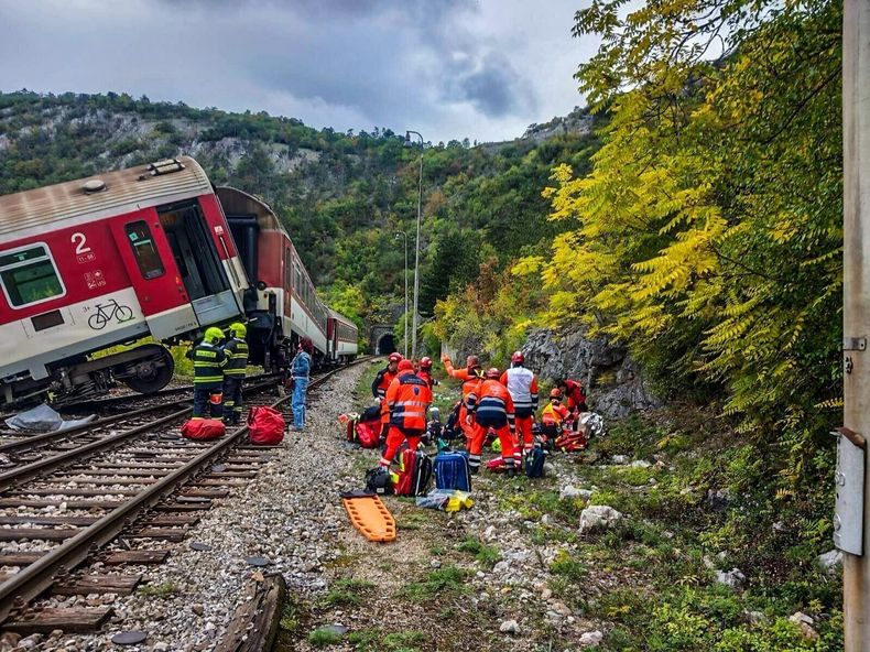 En esta imagen publicada por la policía eslovaca, rescatistas atienden a pasajeros heridos tras un choque de trenes cerca de Roznava, Eslovaquia, el lunes 13 de octubre de 2025. (Slovak Police via AP)