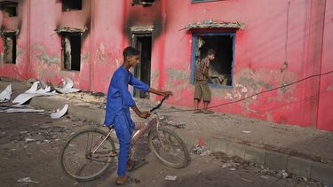 Jóvenes miran una iglesia atacada por una turba de musulmanes enojados en Jaranwala, cerca de Faisalabad, Pakistán, el jueves 17 de agosto de 2023. Musulmanes en el este de Pakistán formaron turbas el miércoles por acusaciones de que un cristiano había profanado un Corán y demolieron la casa del hombre, además de quemar iglesias y dañar otras viviendas, según policías y cristianos locales. (AP Foto/K.M. Chaudary)
