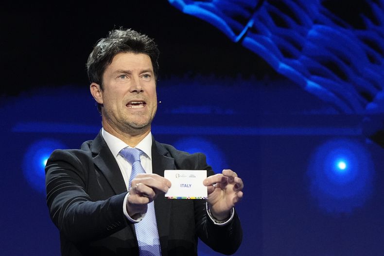 El exjugador de fútbol Brian Laudrup sostiene el papel con el nombre de Italia durante el sorteo para el Campeonato Europeo 2024 en Hamburgo, Alemania el sábado 2 de diciembre del 2023.(AP Foto/Martin Meissner)