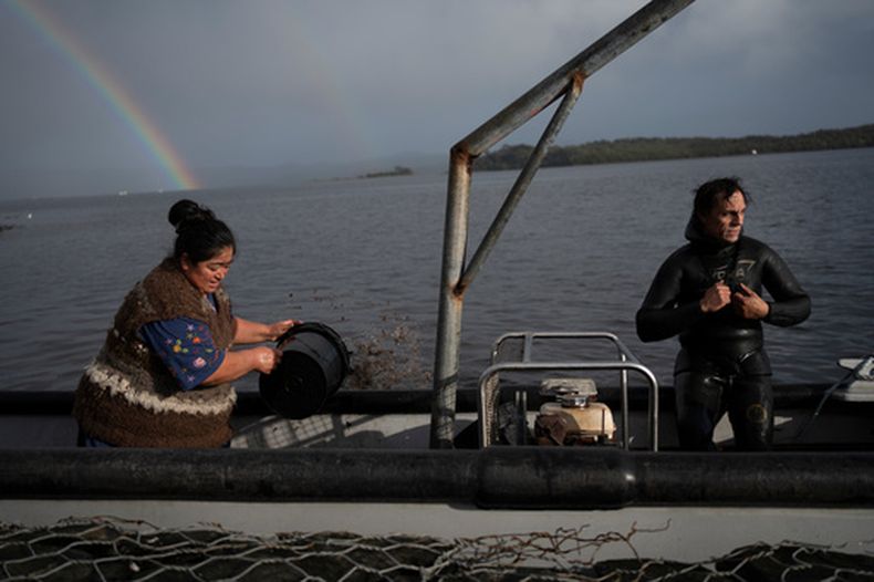 Yesica Fabiana Leviñanco, a la izquierda, y su pareja, Paulo Vera Pérez, se preparan para una jornada de pesca el miércoles 21 de mayo de 2025, en Repollal, en el archipiélago de las Guaitecas, Chile. (AP Foto/Adriana Thomasa)