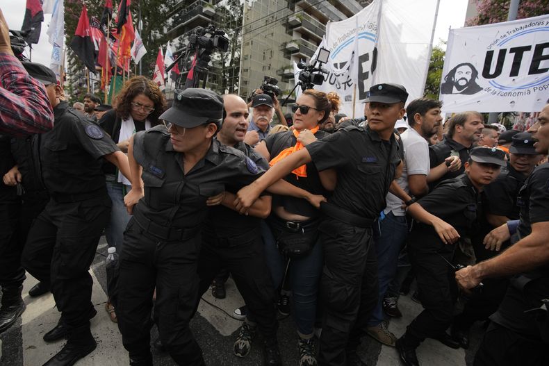 La policía no logra impedir que los manifestantes bloqueen la calle frente al Ministerio de Capital Humano durante una protesta contra la escasez de alimentos en los comedores populares y las reformas económicas del gobierno en Buenos Aires, Argentina, el viernes 23 de febrero de 2024. (AP Foto/Natacha Pisarenko)
