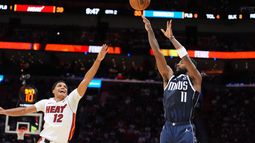 El base de los Mavericks de Dallas Kyrie Irving lanza el balón sobre el base del Heat de Miami Dru Smith en el encuentro del lunes 26 de octubre del 2026. (AP Foto/Rebecca Blackwell)