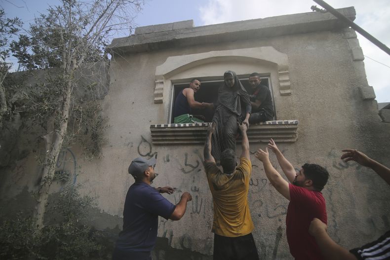 Palestinos desalojan un edificio alcanzado por un bombardeo aéreo israelí sobre la Franja de Gaza, en Rafah, el 22 de octubre de 2023. (AP Foto/Hatem Ali)