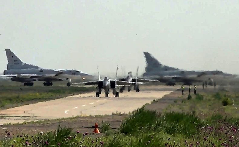 En esta imagen tomada de un video el lunes 10 de junio de 2024 y publicada por el servicio de prensa del Ministerio ruso de Defensa, dos cazas MiG-31 de la fuerza aérea rusa salen para una misión de entrenamiento con dos bombarderos Tu-22M3 de fondo durante maniobras conjuntas de Rusia y Bielorrusia para entrenar al ejército en el empleo de armas nucleares tácticas. (Servicio de prensa del Ministerio ruso de Defensa via AP)