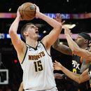 El serbio Nikola Jokic dispara por los Nuggets de Denver frente a Landry Shamet (derecha) y Torrey Craig, de los Suns de Phoenix, en el sexto duelo de la semifinal de la Conferencia Oeste, el jueves 11 de mayo de 2023 (AP Foto/Matt York)