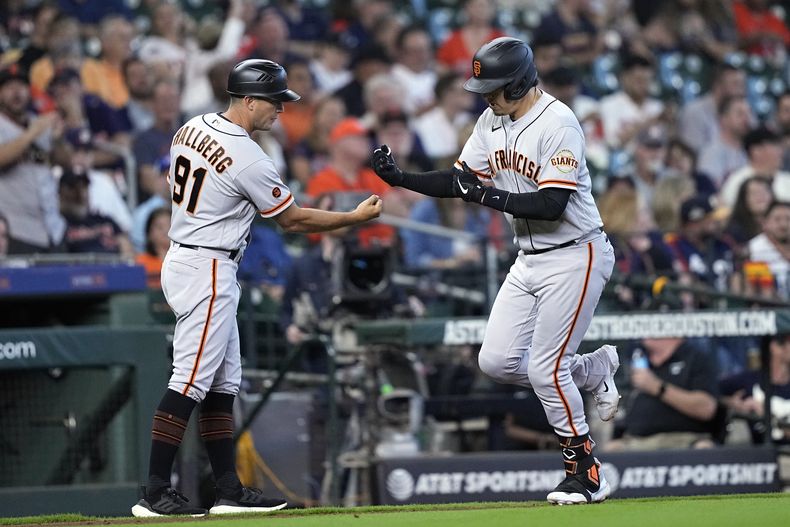 Wilmer Flores, derecha, de los Gigantes de San Francisco, celebra con el coach de tercera, Mark Hallberg (91), después de conectar cuadrangular en contra de los Astros de Houston durante la novena entrada el juego de béisbol, el miércoles 3 de mayo de 2023, en Houston. (AP Foto/David J. Phillip)
