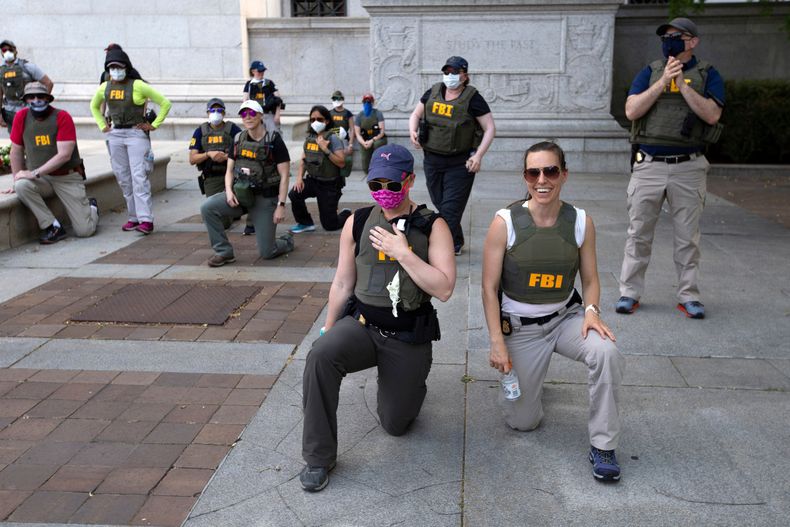 ARCHIVO - Agentes del Buró Federal de Investigaciones (FBI) se arrodillan junto a los manifestantes que marchan por la avenida Pennsylvania, el 4 de junio de 2020, en Washington, durante una protesta por la muerte de George Floyd, un hombre negro desarmado, quien falleció después que un policía le presionara el cuello con la rodilla durante varios minutos. (Foto AP/José Luis Magaña, archivo)