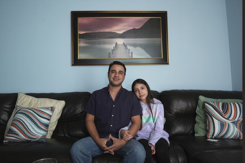 Manuel Castaño, un activista de derechos humanos de Nicaragua de 39 años que trabaja en el mantenimiento de edificios en el sur de Florida, y su hija Emily, de 13 años, posan para una fotografía el lunes 11 de noviembre de 2024 en su casa de Miami. (AP Foto/Wilfredo Lee)